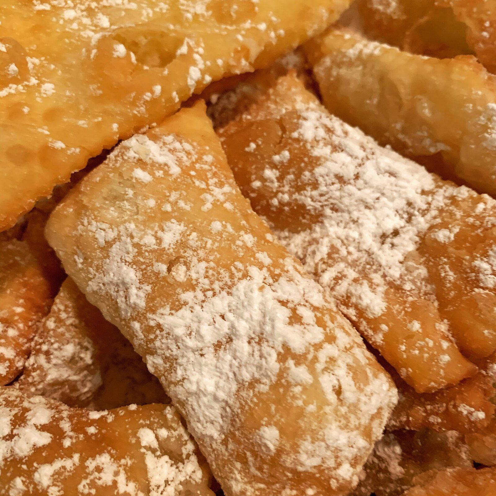 Gros plan sur des beignets de carnaval croustillants saupoudrés de sucre glace