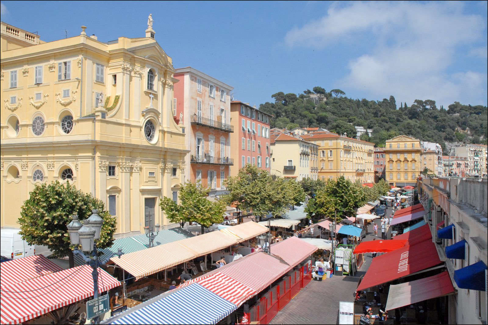 Le marché du cours Saleya à Nice, ses auvents rayés, la chapelle de la Miséricorde et la colline du Château
